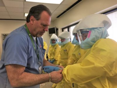 PPE Session with students in yellow hazmat suits in Summer Outbreak Course