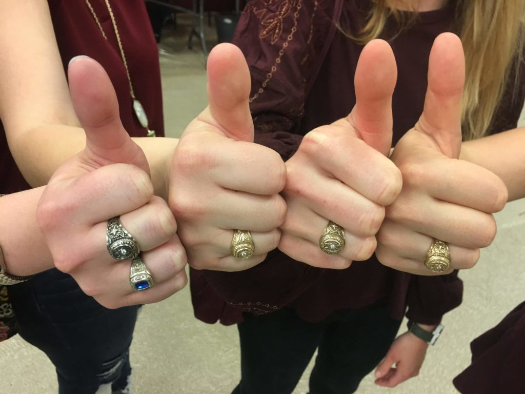 Group making gig'em signs and showing their Aggie ring 