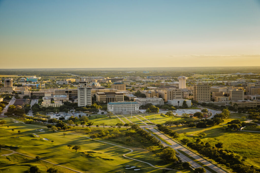 An aerial photo of the Texas A&M campus at sunset including a view of the Academic Building and the Aggie water tower.