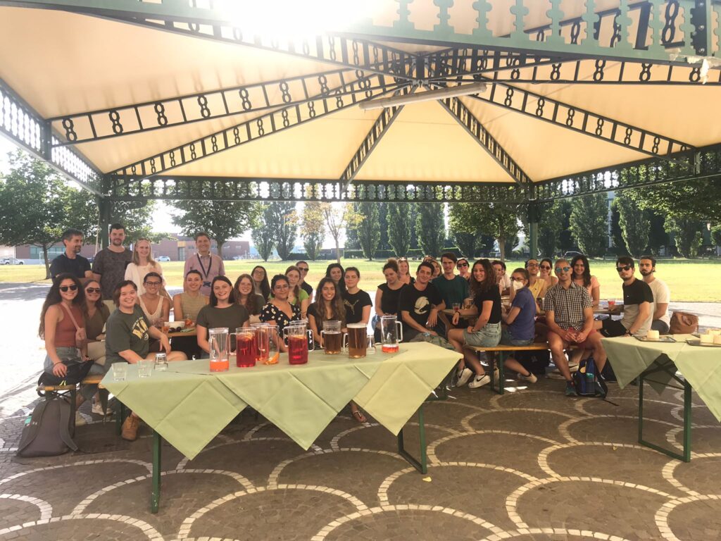 A large group of students gathered under an Italian pavillion for a photo.