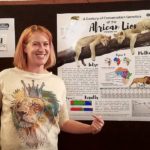 Caitlin Curry in front of her poster on lions