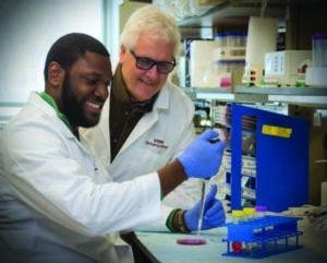 graduate research student in the lab with his faculty mentor
