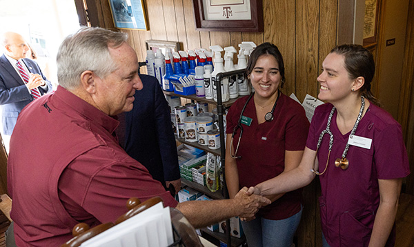 Mark Welsh shakes hands with Audrey Young and Jessica Counsil