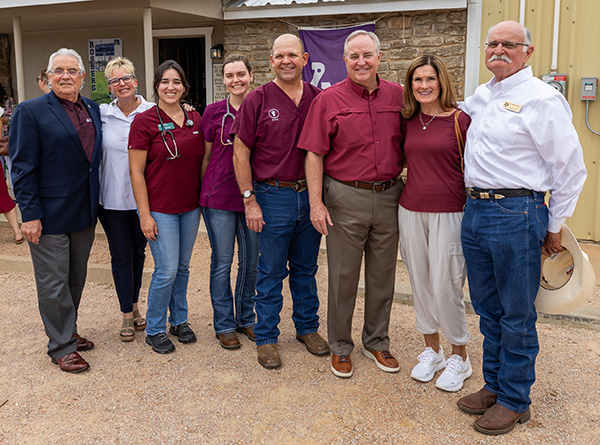 Several people pose in front of a veterinary clinic