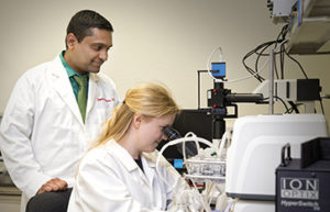 Student with professor at a microscope in the lab