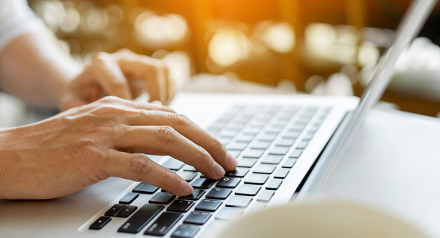 Man hands typing on laptop keyboard