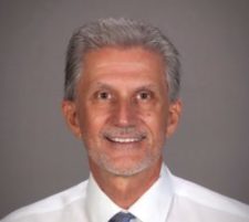 Headshot of seminar speaker Dr. David Castellan in white shirt with blue tie
