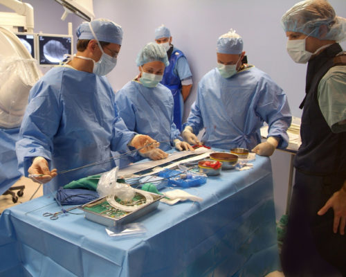 Veterinary and human doctors are shown preparing equipment for the non-invasive heart procedure.