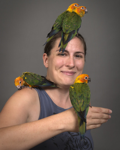 Ph.D. student Connie Woodman with sun conures
