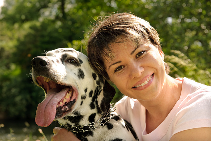woman embracing with her Dalmatian dog outdoors