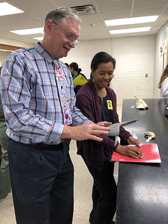 Dr. Larry Johnson teaches a student with a grey anatomical specimen