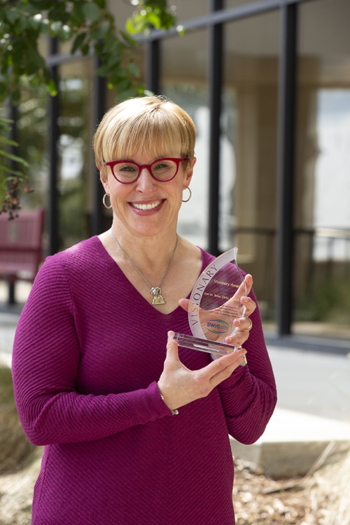 Teller holding the Southwest Veterinary Symposium Visionary of the year award