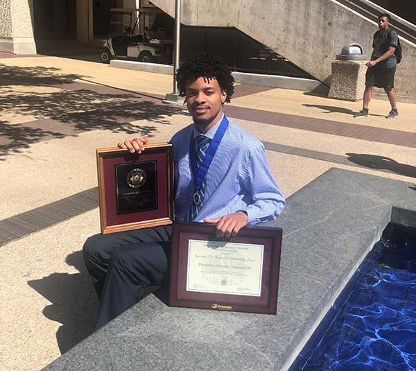 Demonta Coleman with his awards in Rudder plaza