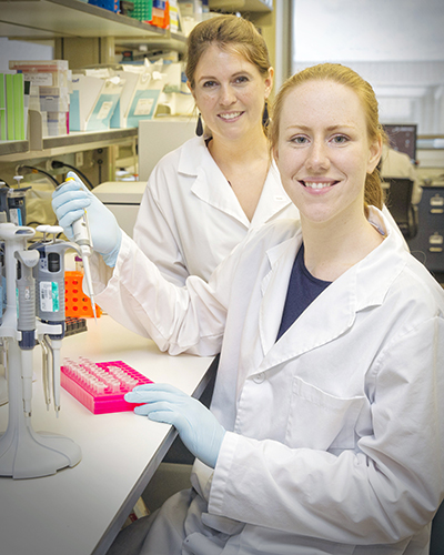 Alyssa Meyers, Ph.D., (back) and Megan Ellis pipetting in the lab