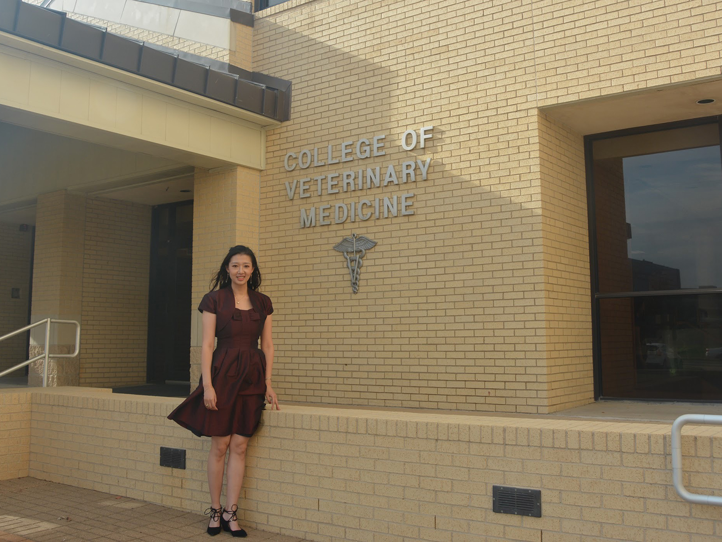 CVMBS Postdoc Meichen Wang in front of the old College of Veterinary Medicine entrance