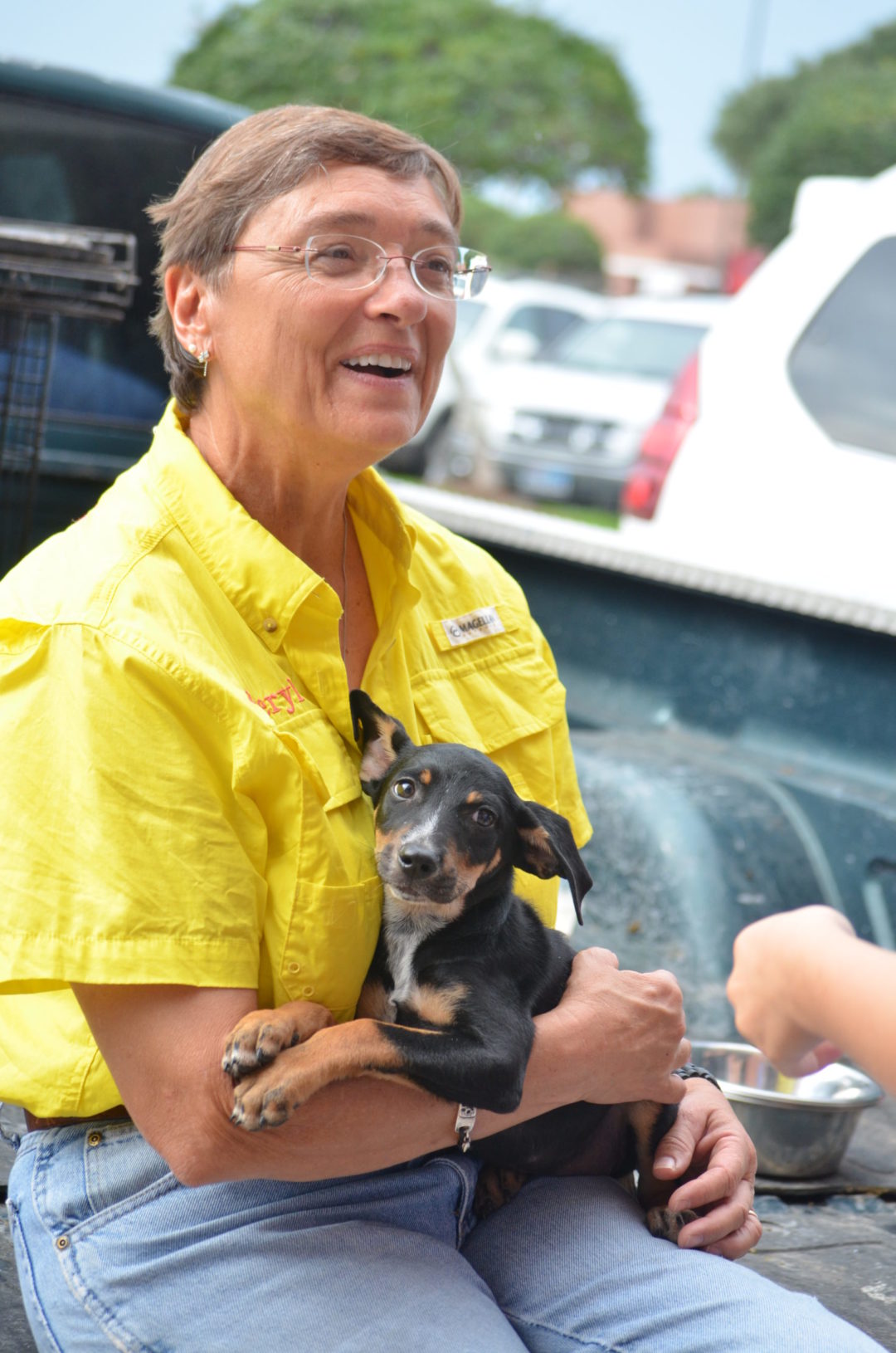 Cheryl Mellenthin holding a small black and brown dog