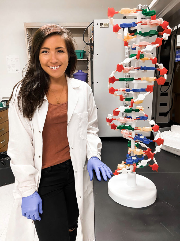 Allie Folcik next to a large DNA model