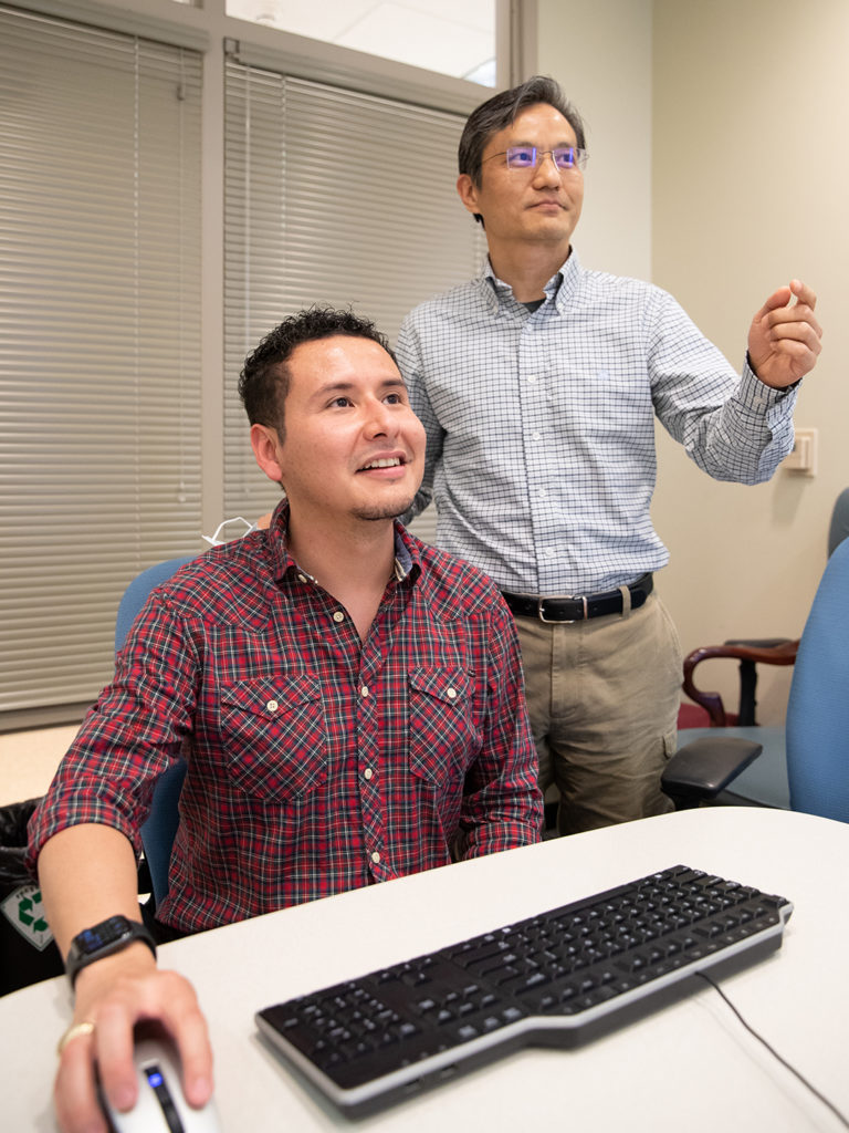 Daniel Osorio and Dr. James Cai working at a computer