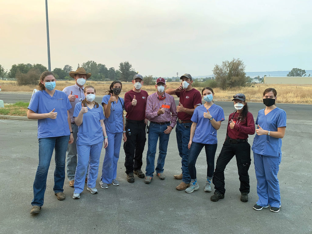 A group of people in blue scrubs or maroon VET shirts