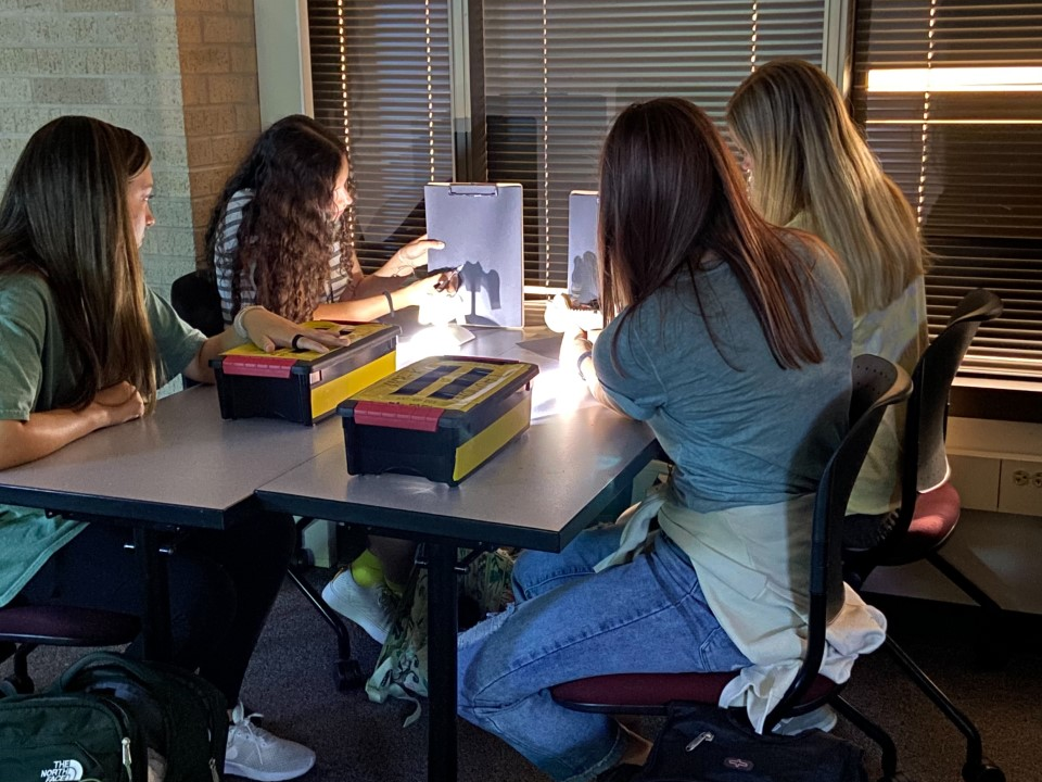four students at a table making simulated radiographs
