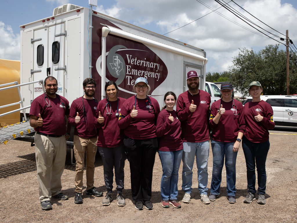 Eight veterinary students in maroon VET shirts standing in front of a VET truck
