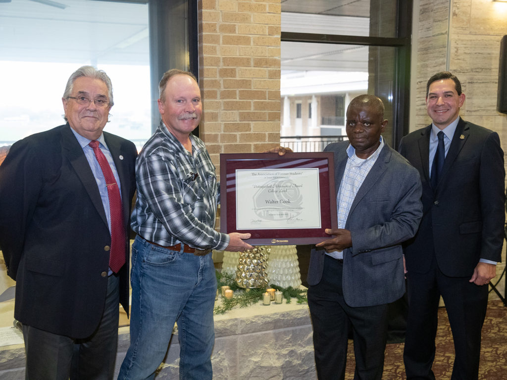 Dr. John August, Dr. Walt Cook, Dr. Albert Mulenga, and Andrew Arizpe with an AFS college-level award certificate