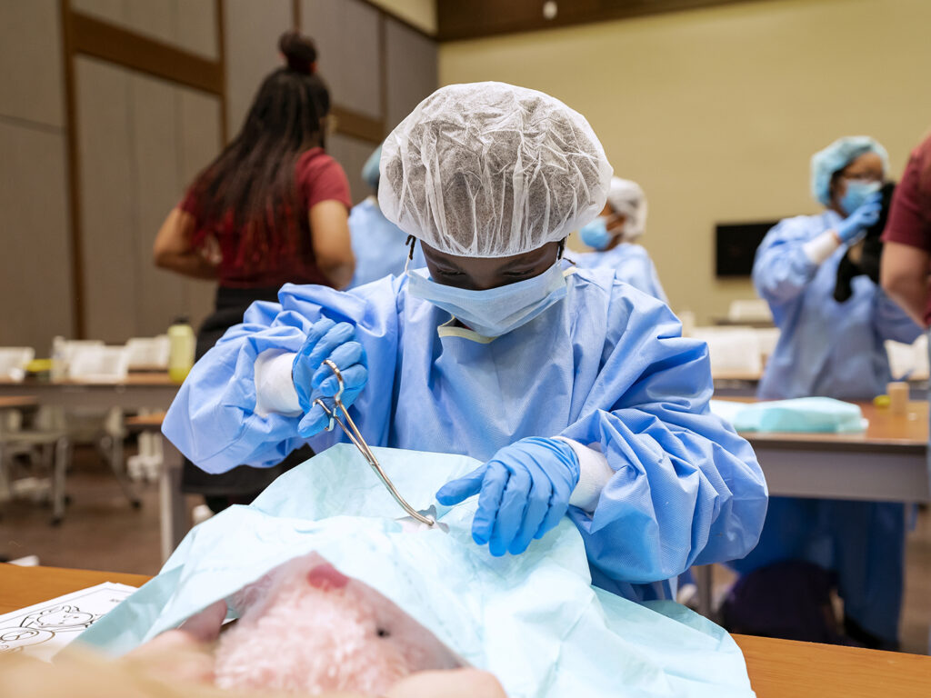 A child in surgical gear "operates" on a stuffed animal