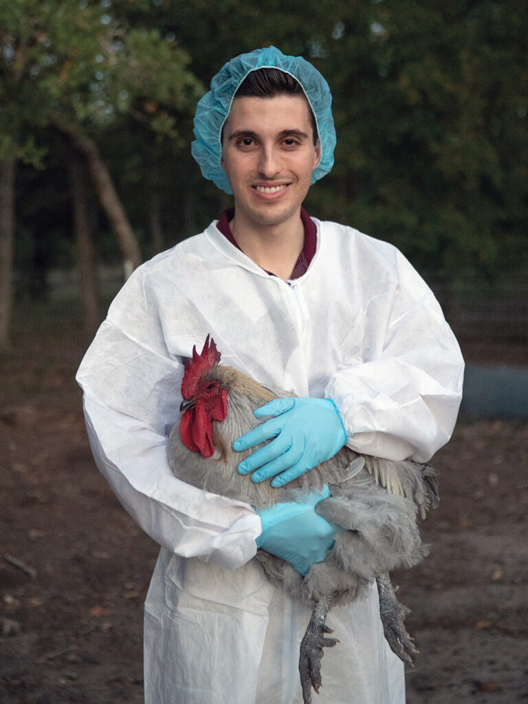 Jason Sousa in PPE holding a grey rooster