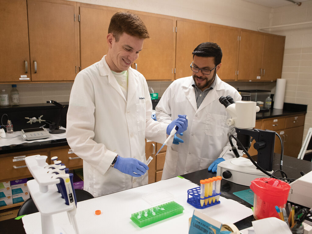 Verocai and a student in white lab coats conducting research