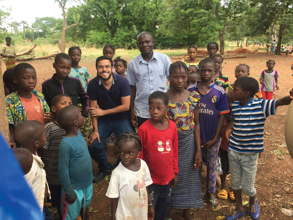 Verocai surrounded by a group of children and young adults from Burkina Faso
