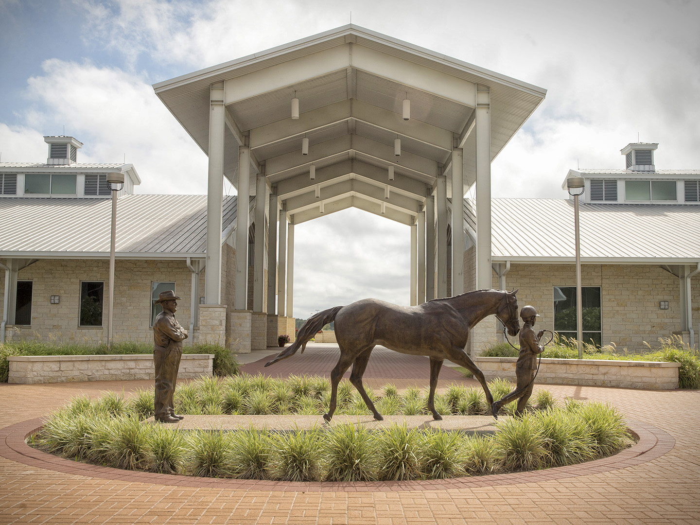 The Thomas G. Hildebrand DVM ’56 Equine Complex with a statue of two people and a horse