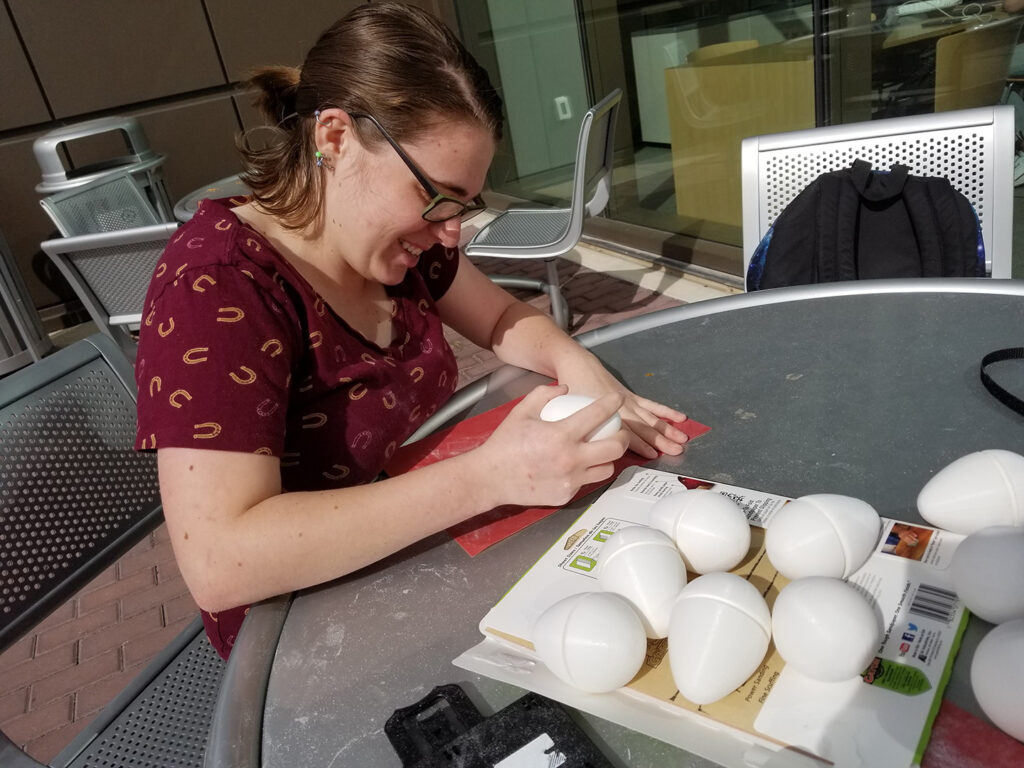 A student sanding an artificial egg
