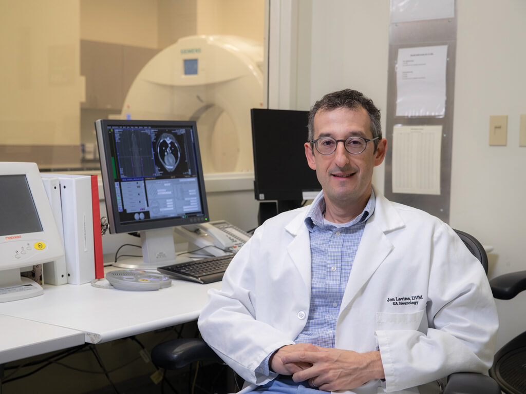 Levine sitting at a desk with an MRI machine in the background