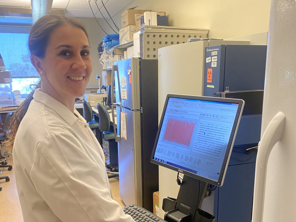Trainee Lucie Ford working at a screen in a lab