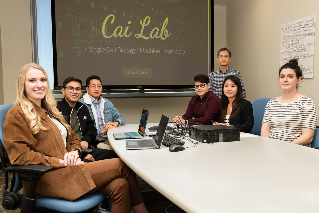 The Cai lab team sitting around a table