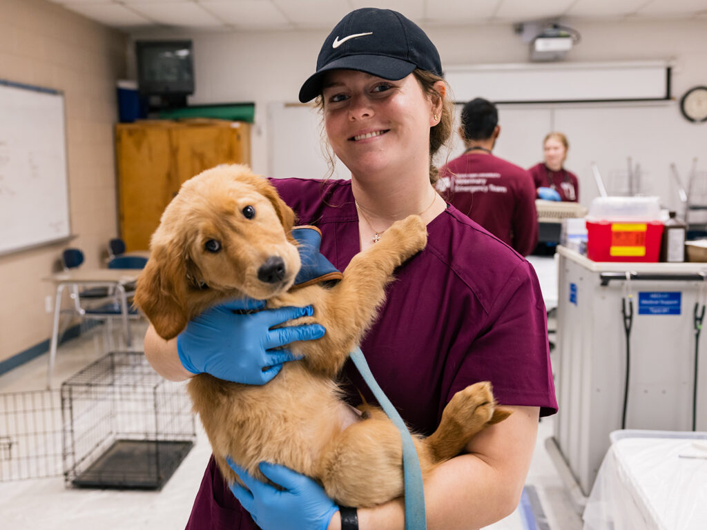 Veterinary student holding a fluffy puppy