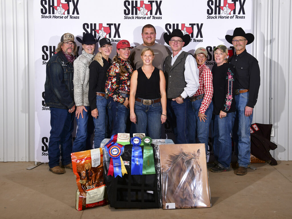 Group photo with Fridley behind prizes and photo of her horse Ace