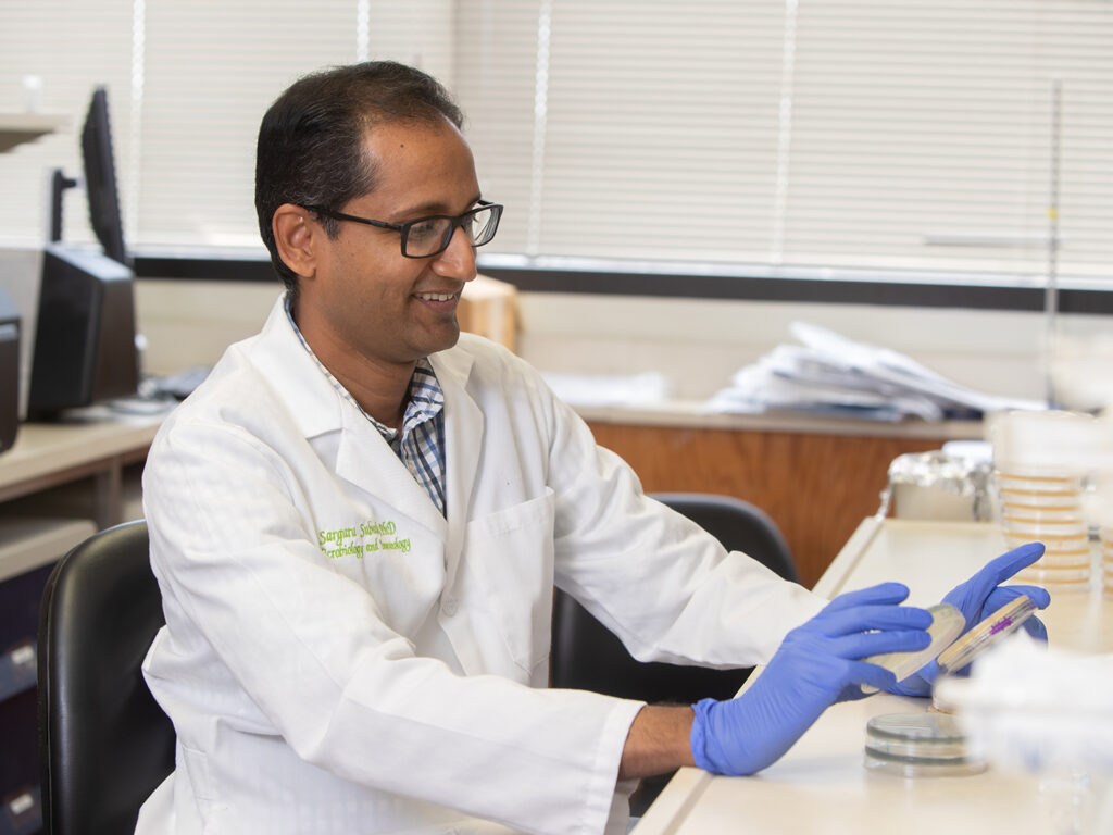 Dr. Subash looking at a petri dish