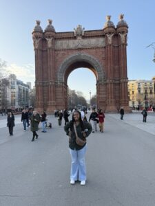 A young woman posing in front of the Arc de Triomf in Barcelona, Spain