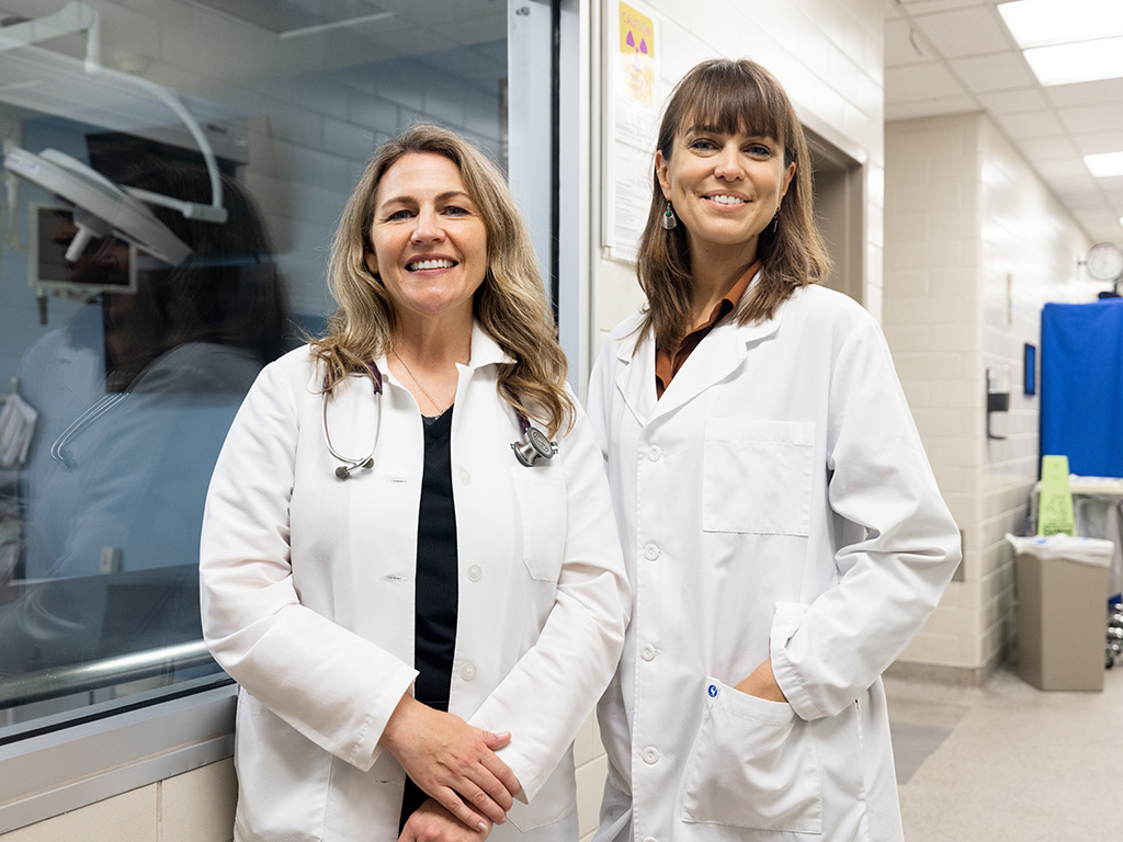Two female professors in white coats in a hospital.