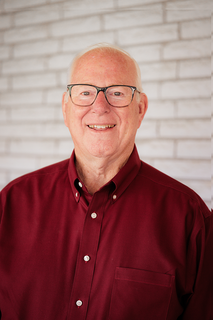 A headshot of a man in a maroon button-down shirt.