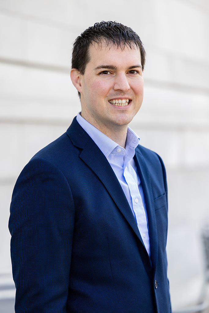 A headshot of a man in a blue suit.