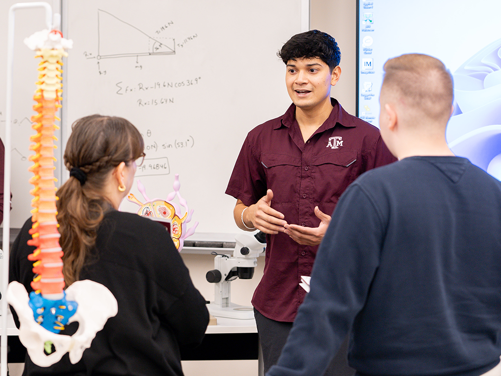 A college student in maroon gives a presentation.
