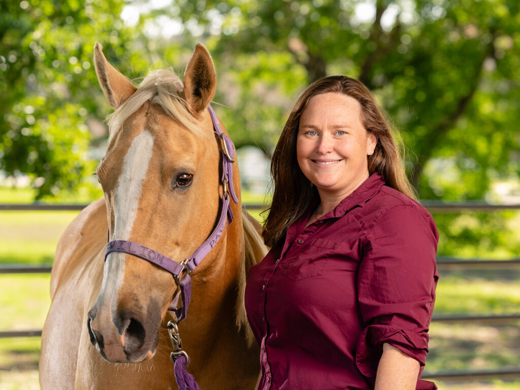 Dr. Kallie Hobbs and a tan horse standing outside
